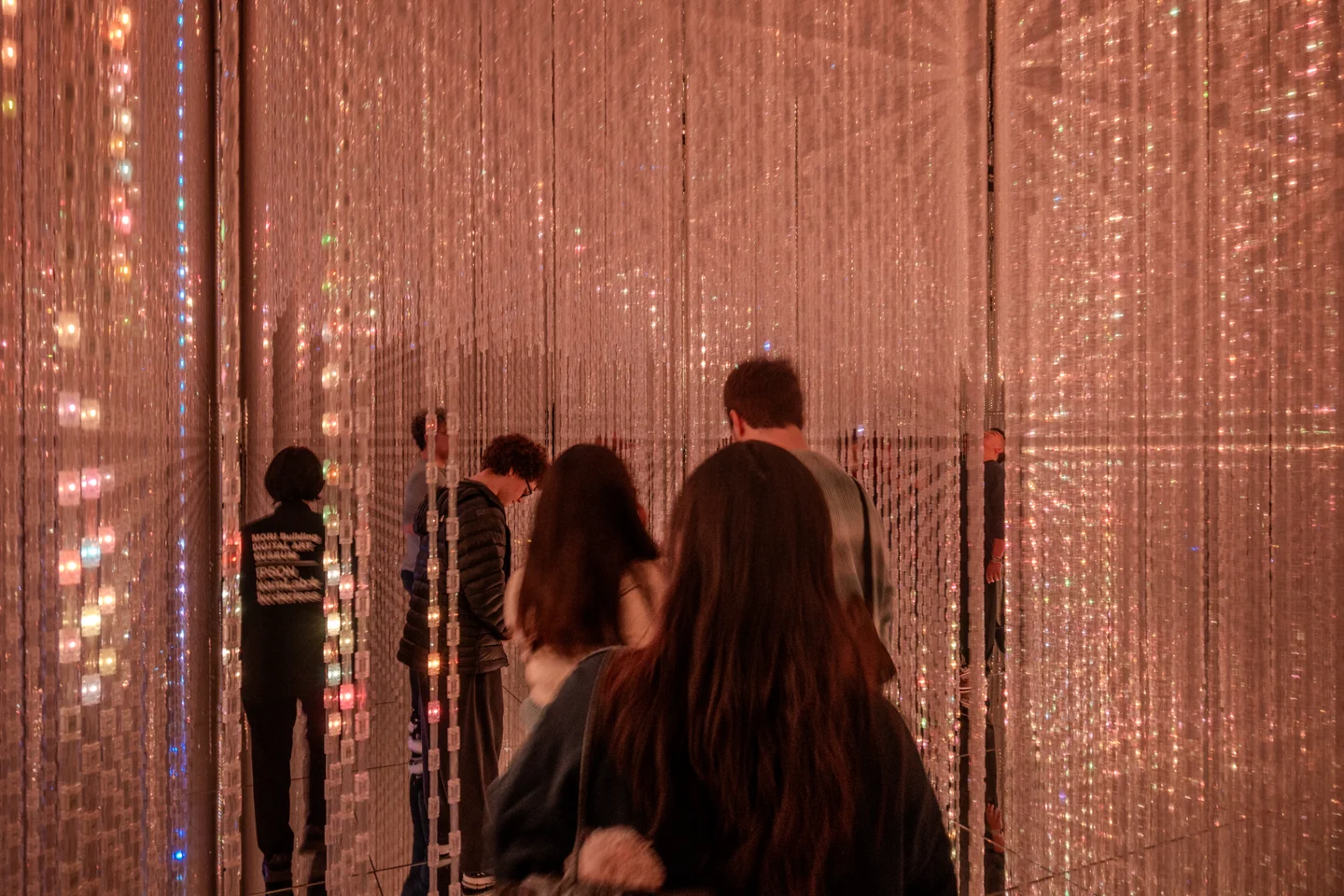 Room with mirrors and long light ropes hanging from the ceiling
